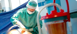 수술실에서 지방을 채취하는 의료진과 붉은 뚜껑 흡입 용기