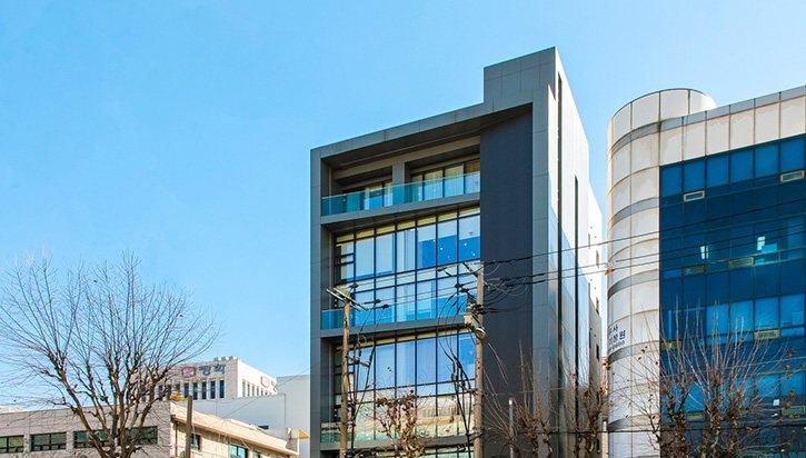 유리와 회색 외벽의 병원 건물 외관(낮)